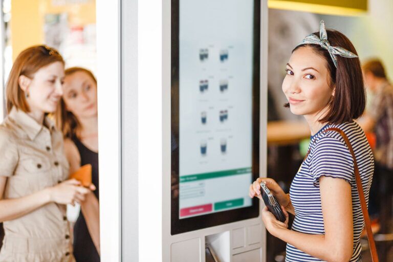 Ragazza ordina sul totem di un ristorante