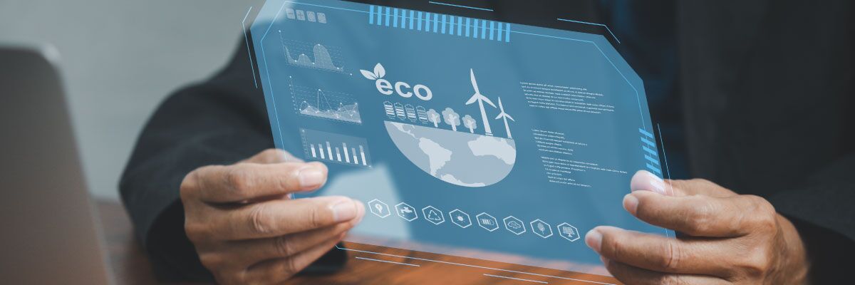 Persona alla scrivania tiene immano un'immagine digitale con dati che si riferiscono alla sostenibilità