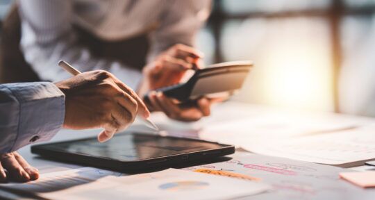 blog ERP Forecasting mani di una persona che utilizza un tablet e una calcolatrice