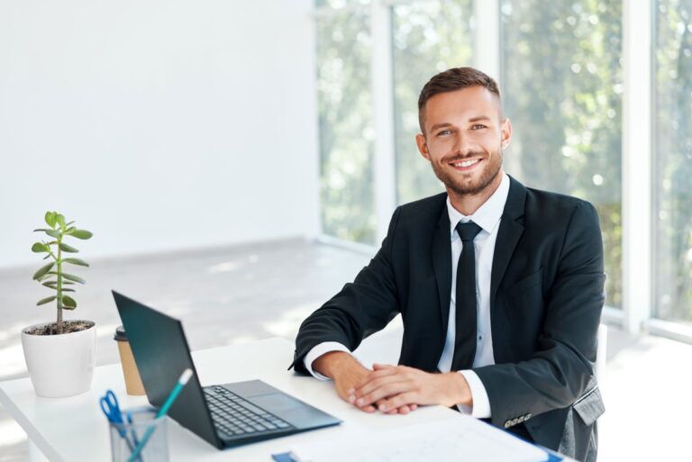 Manager sorride mentre utilizza il software ERP dell'azienda sul computer.