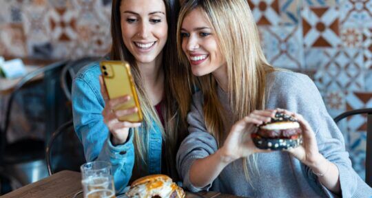 Ragazze utilizzano il borsellino elettronico in un ristorante