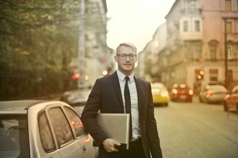 IT Manager sorride con un computer al di fuori dell'azienda.