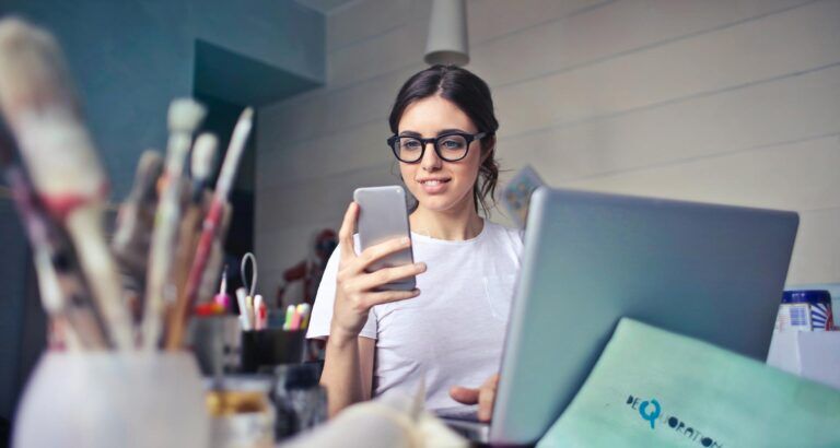 Guezzt Ragazza sorride mentre guarda una mail nello smartphone.