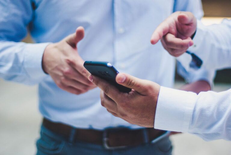 Due membri del team vendite guardano lo smartphone.