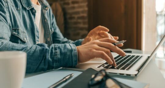uomo impiegato al lavoro che legge info di data governance act al PC