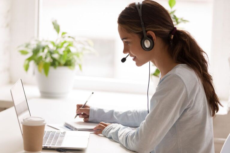 Ragazza del customer service prende appunti mentre è al telefono.