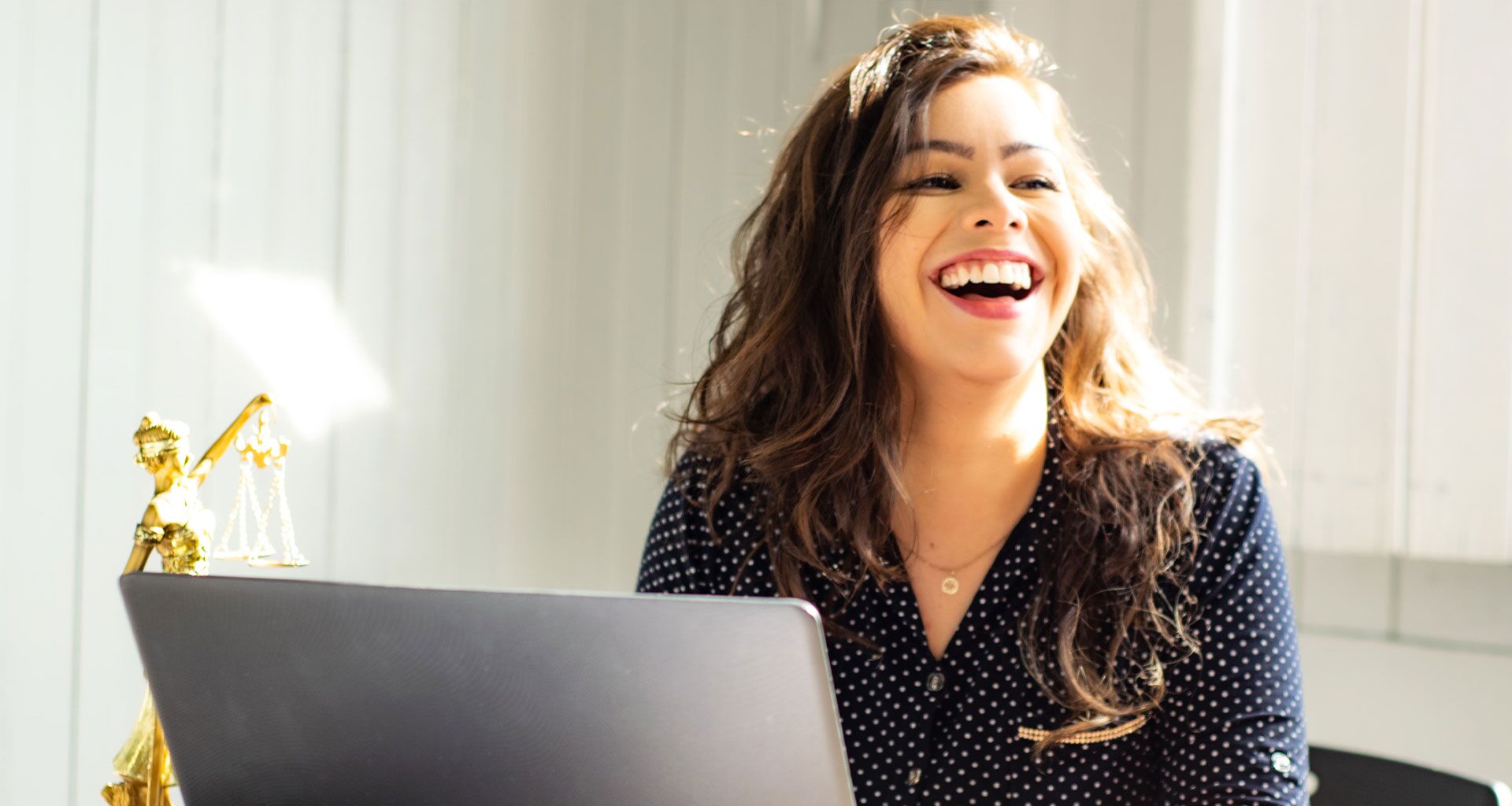 Impiegata dell'amministrazione che sorride mentre guarda il computer.