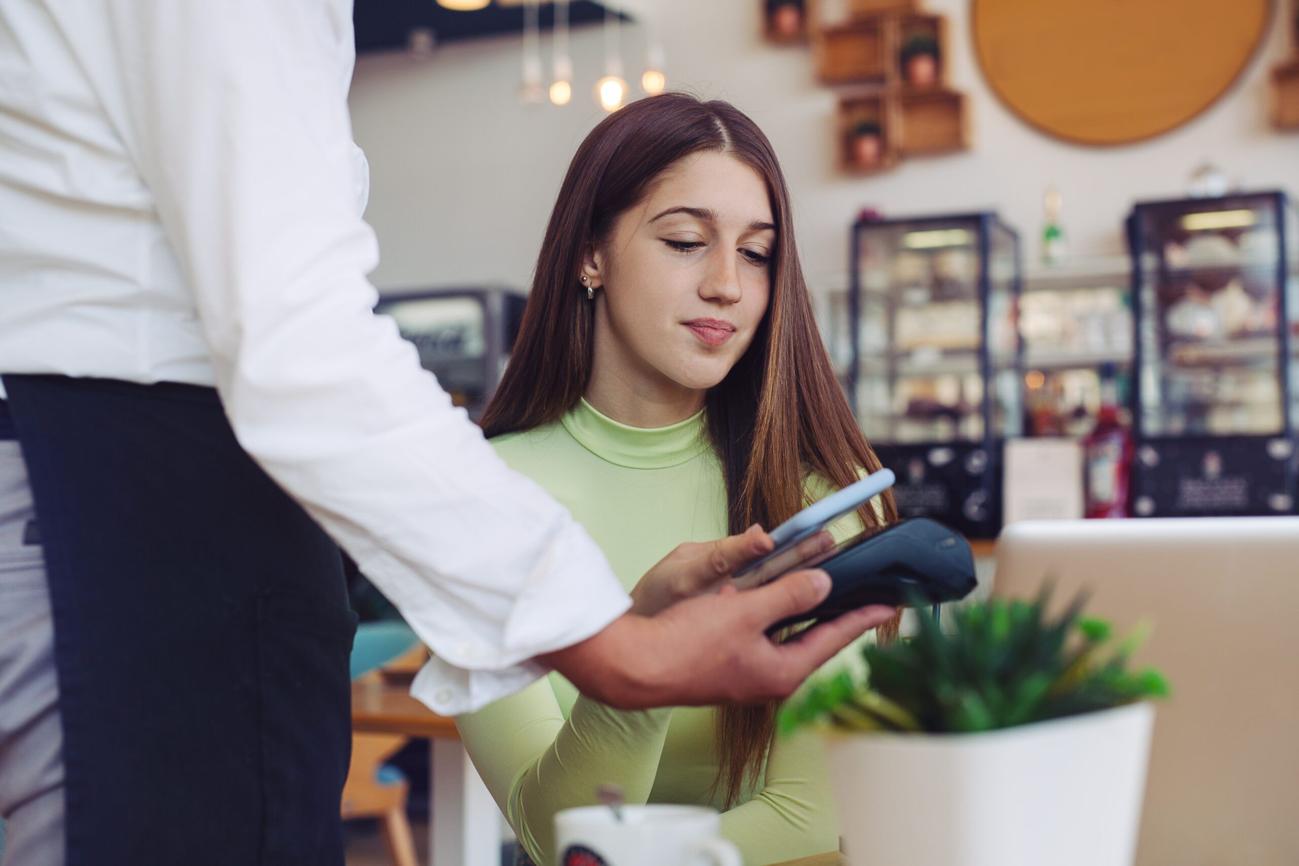 Ragazza al ristorante paga con la carta di credito grazie a Planet Payment per ristoranti