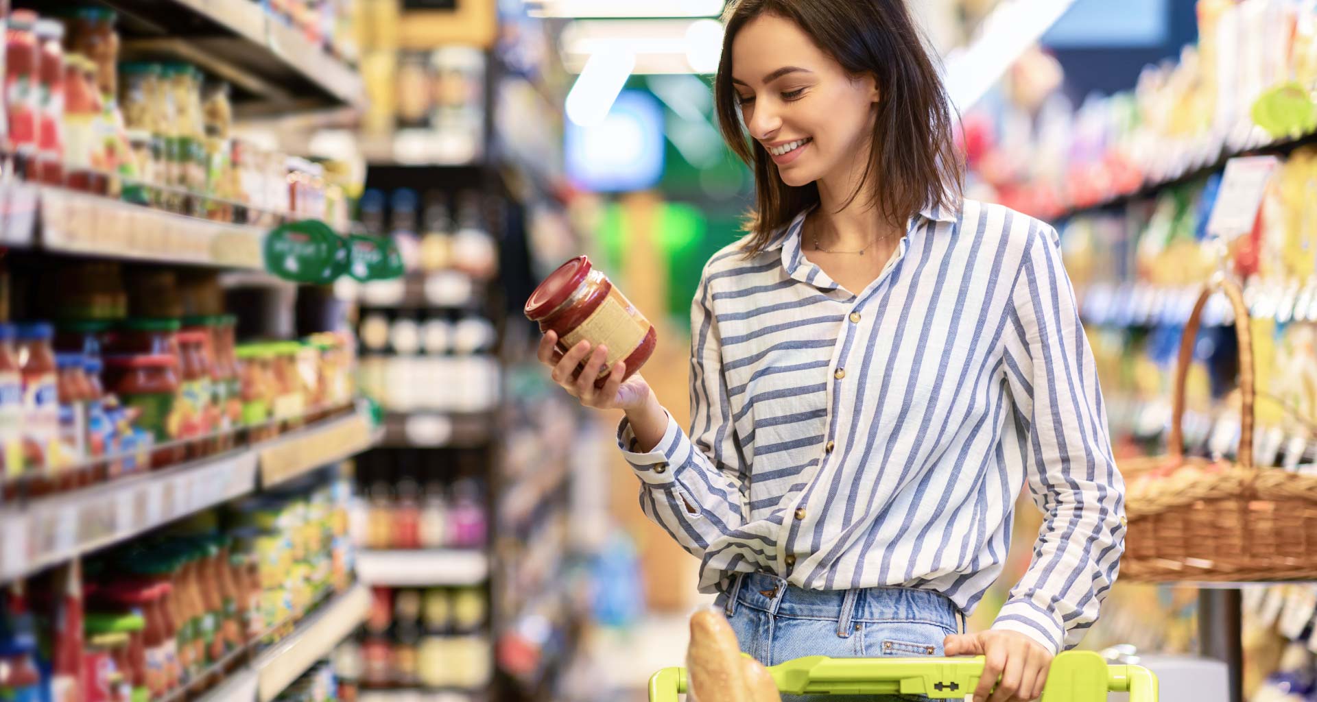 Spesa facile: acquirente nella corsia del supermercato acquista una passata di pomodoro