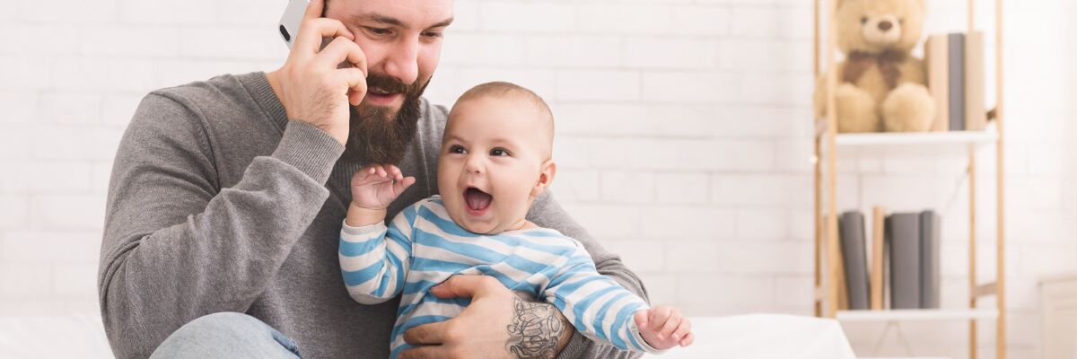 Bonus Bebè: Padre al telefono con il figlio in braccio. 