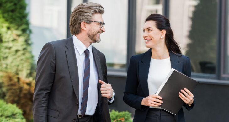 Horeca: uomo e donna in tenuta professionale passeggiano e si sorridono