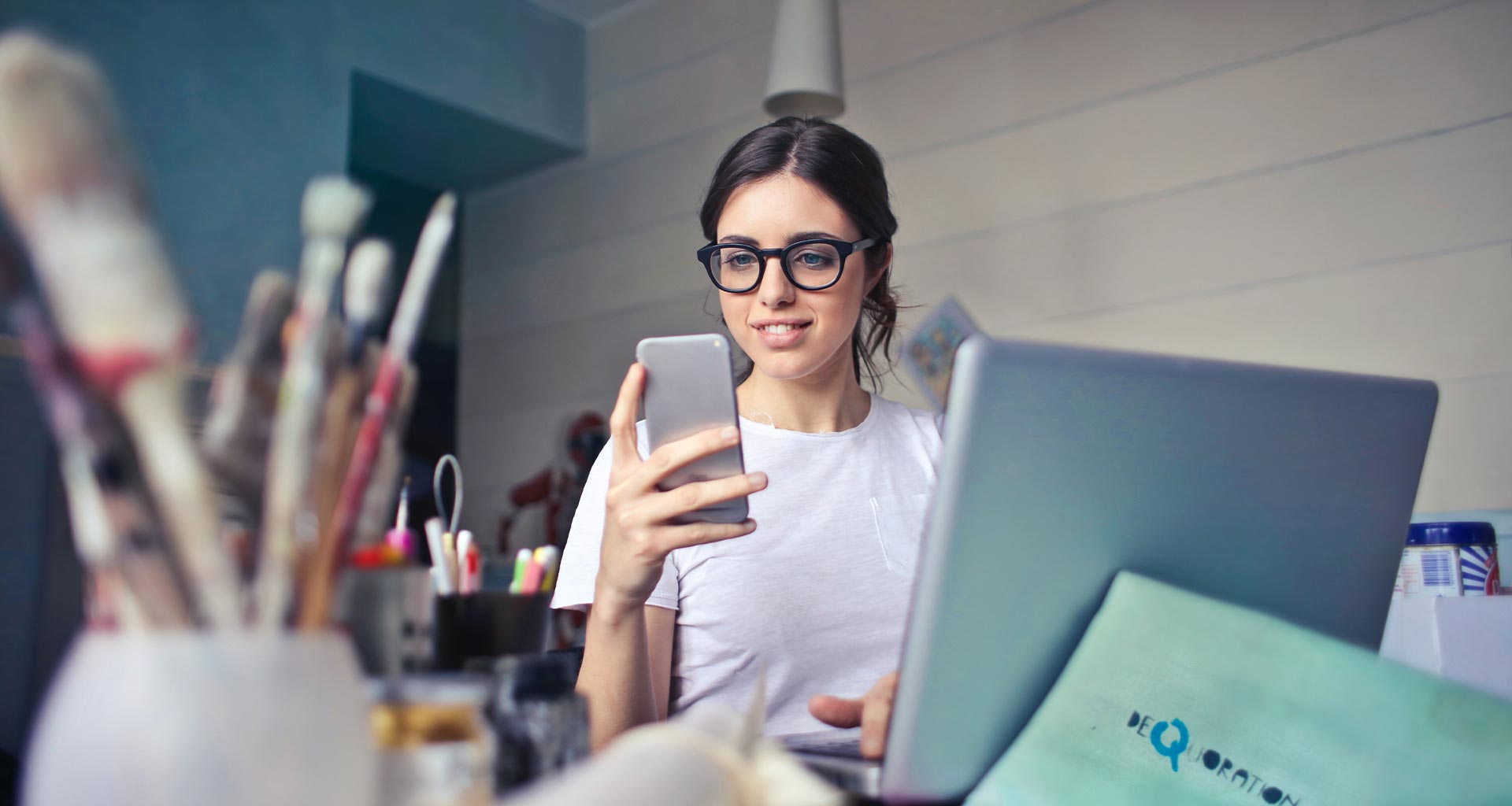 Ragazza sorride mentre guarda una mail nello smartphone.